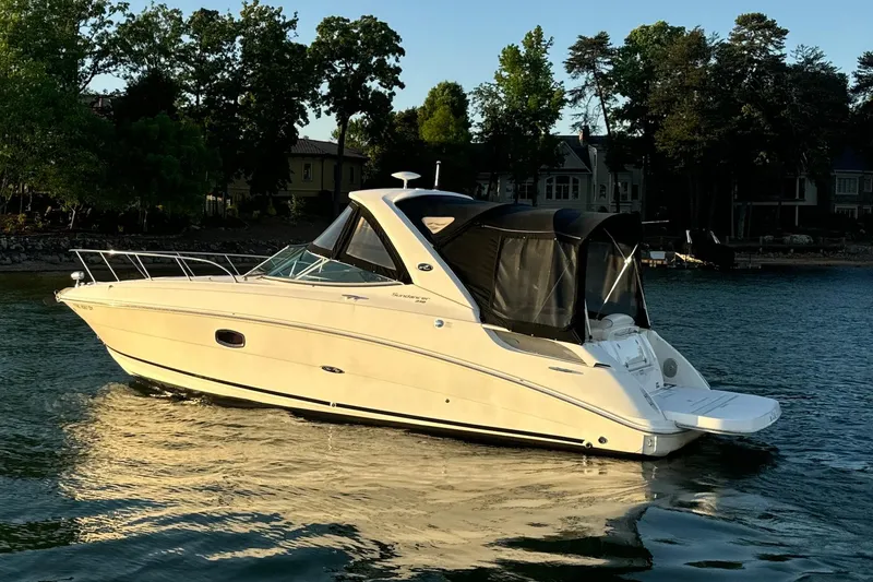 The Image of 2012 Sea Ray Sundancer 310 boat on calm water near shoreline. - 0