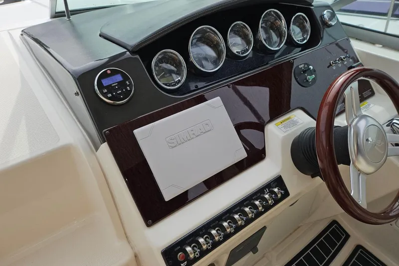 Slide: The Image of Cockpit of 2012 Sea Ray Sundancer 310 with steering wheel and instrument panel. - 11