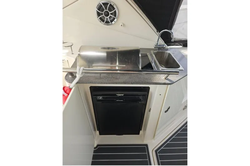 Slide: The Image of 2012 Sea Ray Sundancer 310 boat kitchenette with sink, grill, and mini fridge. - 13