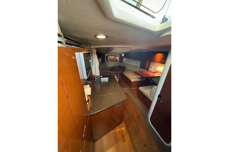 Slide: The Image of Interior of 2012 Sea Ray Sundancer 310 yacht, featuring a cozy cabin and kitchenette. - 15