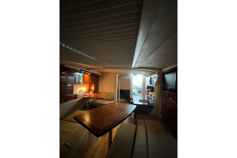 Slide: The Image of Interior of 2012 Sea Ray Sundancer 310 yacht, featuring cozy seating and wooden table. - 17