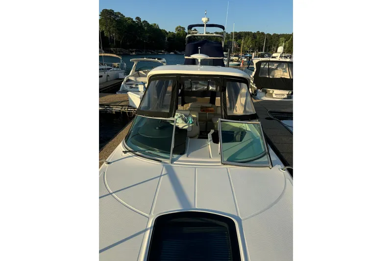 Slide: The Image of 2012 Sea Ray Sundancer 310 docked at marina, surrounded by other boats. - 19