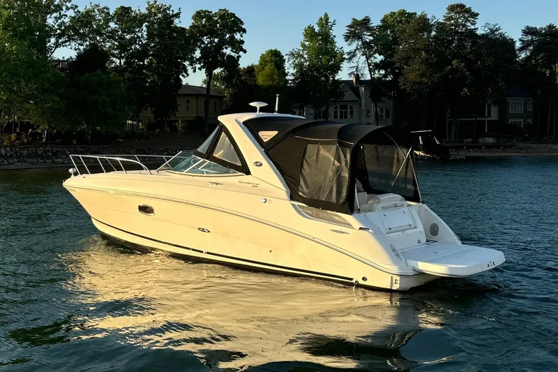 Slide: The Image of 2012 Sea Ray Sundancer 310 boat on calm water near shoreline. - 2