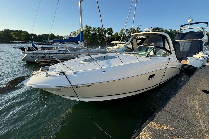 Slide: The Image of 2012 Sea Ray Sundancer 310 docked at marina, surrounded by other boats. - 21