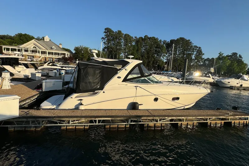 Slide: The Image of 2012 Sea Ray Sundancer 310 docked at a marina, surrounded by other boats. - 22