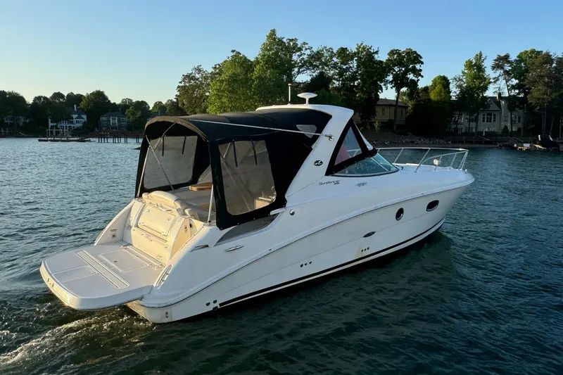 Slide: The Image of 2012 Sea Ray Sundancer 310 boat on a serene lake, surrounded by trees. - 3