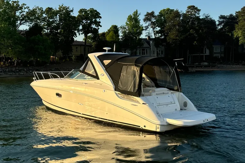 Slide: The Image of 2012 Sea Ray Sundancer 310 boat on calm water, surrounded by trees. - 4