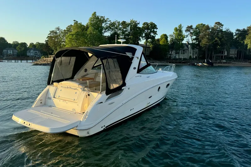 Slide: The Image of 2012 Sea Ray Sundancer 310 yacht on serene water near a wooded shoreline. - 5