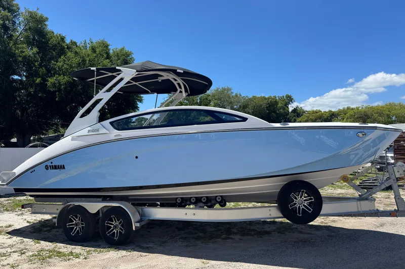 The Image of 2025 Yamaha Boats 275SE on trailer, sleek design, sunny day, outdoor setting. - 0