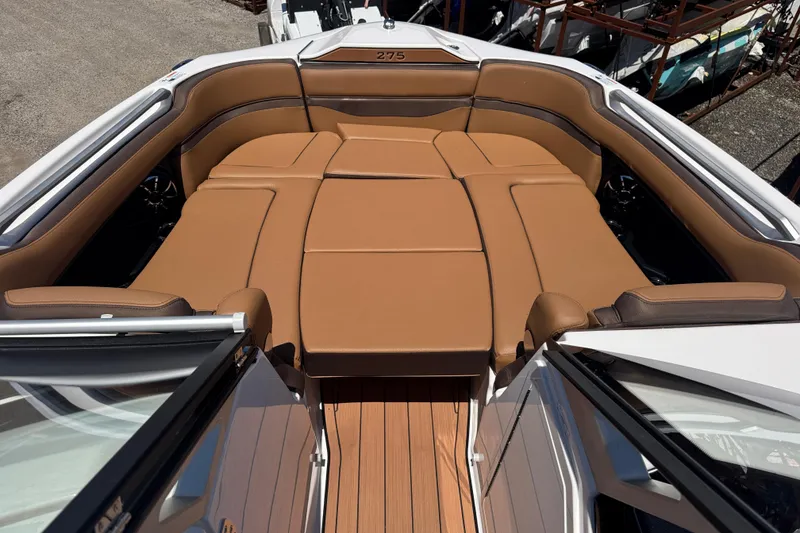 Slide: The Image of 2025 Yamaha Boats 275SE interior with tan leather seating and wooden flooring. - 10