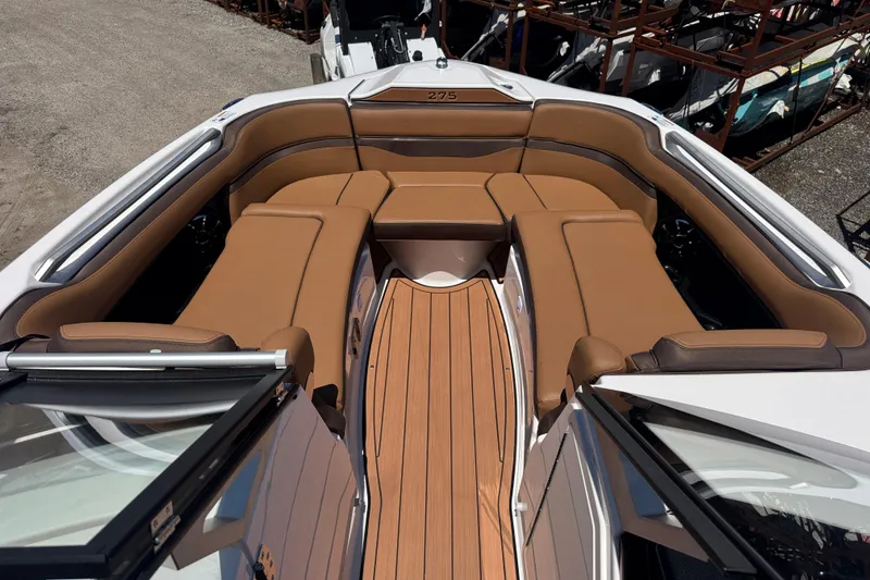 Slide: The Image of 2025 Yamaha Boats 275SE interior with brown seating and wood-style flooring. - 11