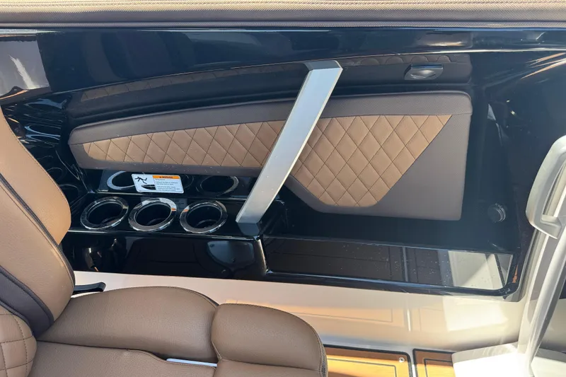Slide: The Image of Interior of 2025 Yamaha Boats 275SE featuring brown leather seats and cup holders. - 17