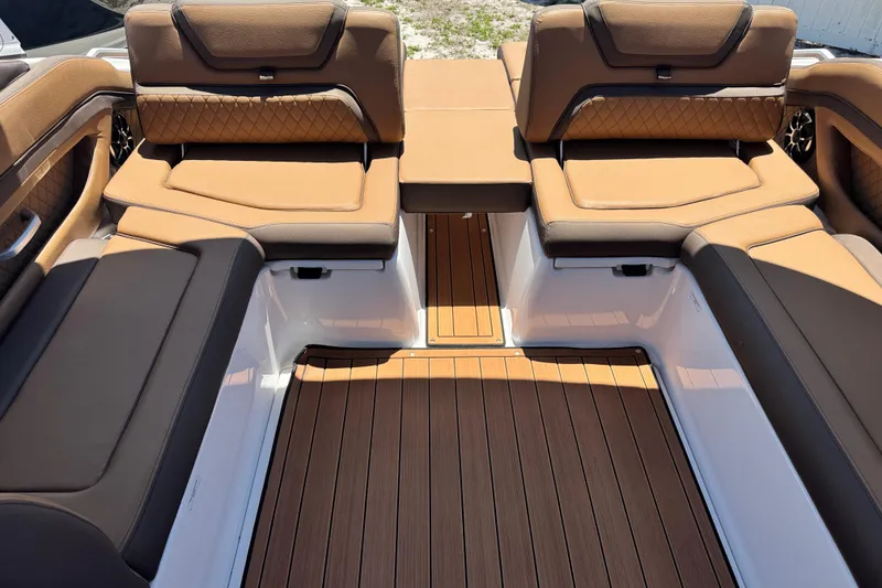 Slide: The Image of Luxurious interior of 2025 Yamaha Boats 275SE with tan leather seating and wood flooring. - 19