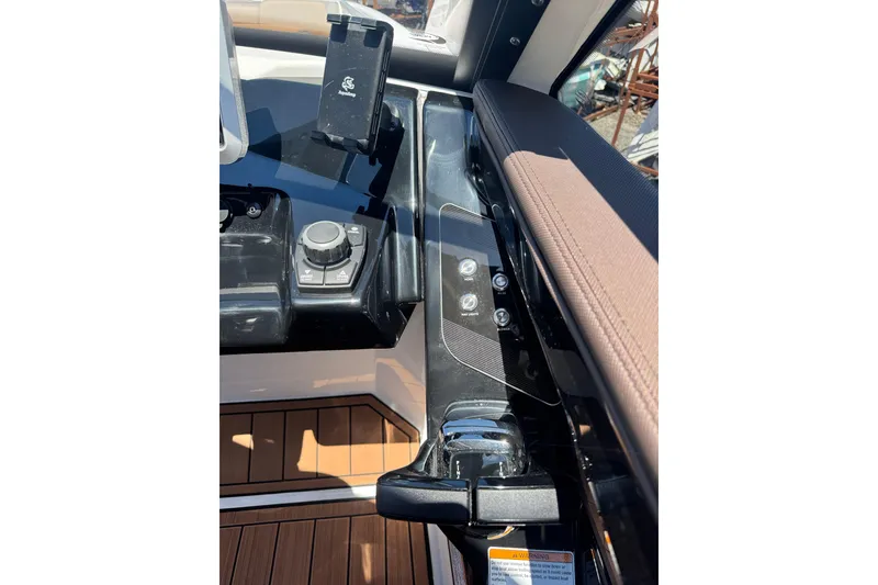 Slide: The Image of 2025 Yamaha Boats 275SE dashboard with control panel and phone holder. - 23