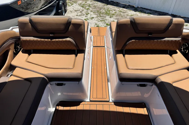 Slide: The Image of 2025 Yamaha Boats 275SE interior with tan leather seating and wood-style flooring. - 27