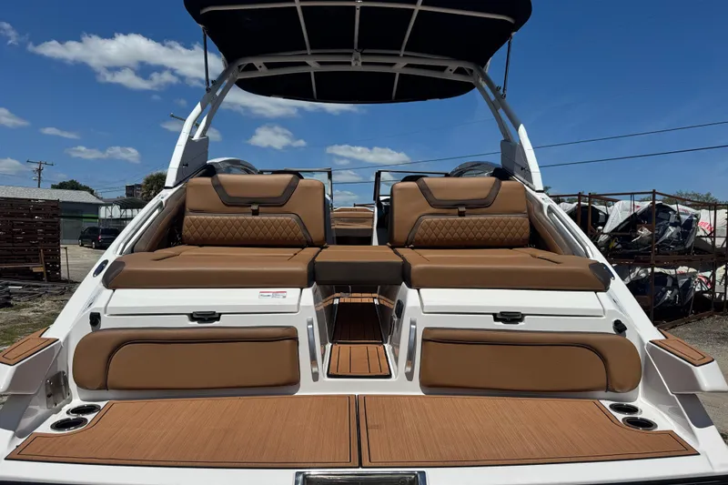 Slide: The Image of 2025 Yamaha Boats 275SE with luxurious brown seating and sleek design under a clear sky. - 4