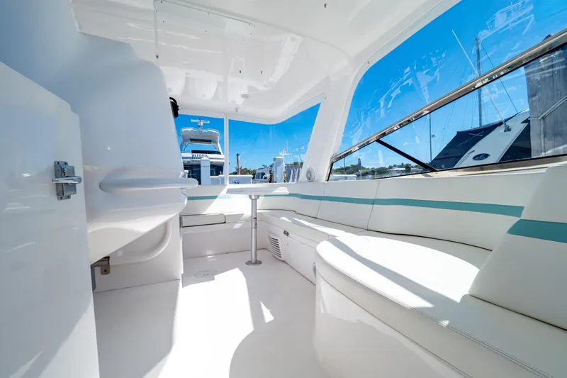 Slide: The Image of 2018 Intrepid 475 Sport Yacht interior with white seating and panoramic windows. - 120