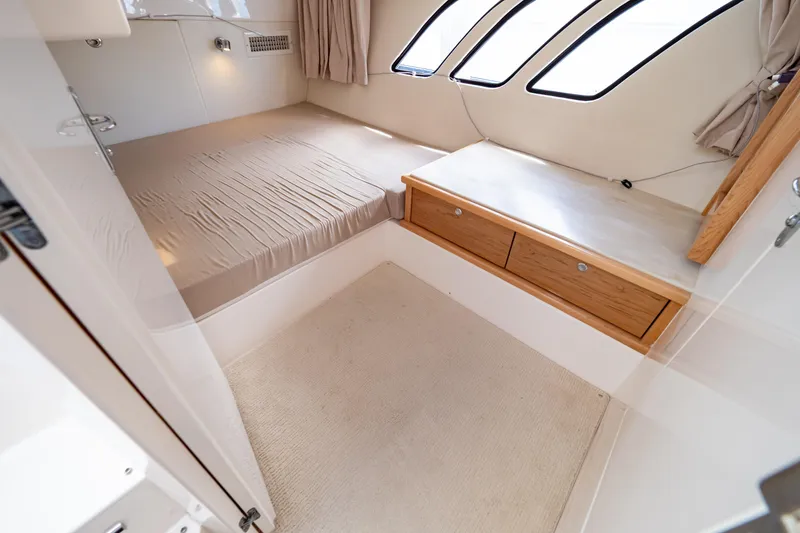 Slide: The Image of 2018 Intrepid 475 Sport Yacht cabin with bed, drawers, and windows. - 143