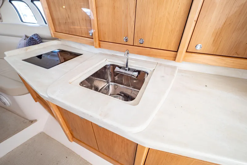 Slide: The Image of 2018 Intrepid 475 Sport Yacht interior with sink and wooden cabinets. - 15