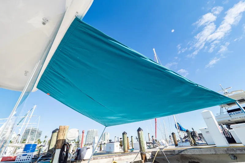 Slide: The Image of Intrepid 475 Sport Yacht 2018 with blue sunshade at marina dock. - 32