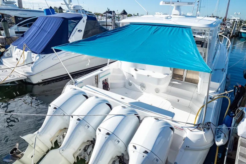 Slide: The Image of 2018 Intrepid 475 Sport Yacht docked with blue sunshade and multiple outboard engines. - 36