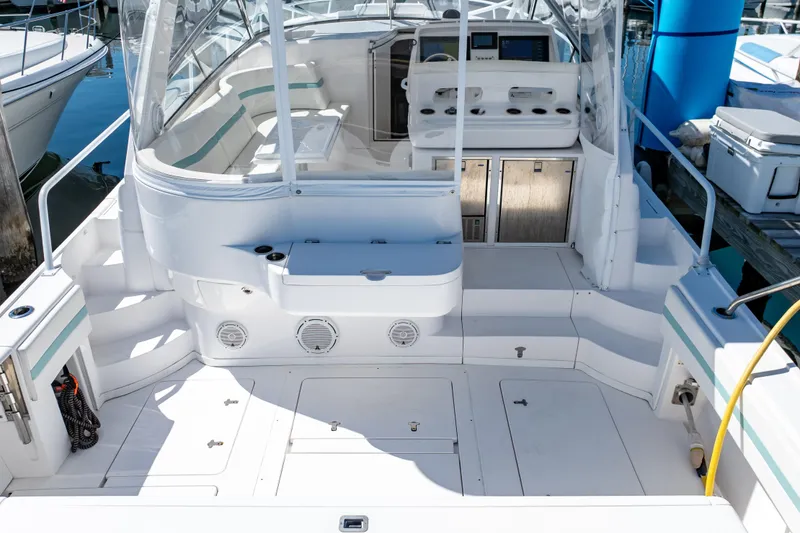 Slide: The Image of 2018 Intrepid 475 Sport Yacht cockpit with seating and control panel, docked at marina. - 6