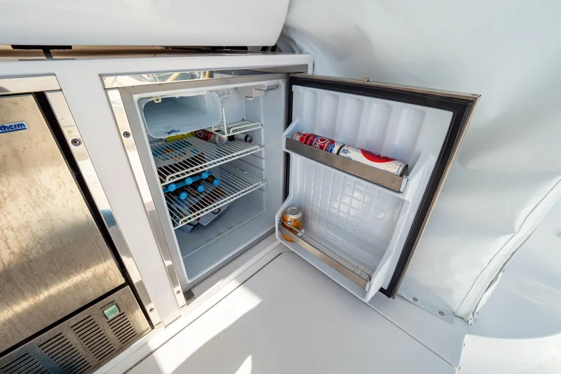 Slide: The Image of Open mini fridge on 2018 Intrepid 475 Sport Yacht, stocked with drinks and snacks. - 89