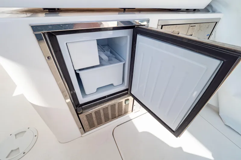 Slide: The Image of Open freezer compartment on 2018 Intrepid 475 Sport Yacht, showcasing interior storage space. - 90