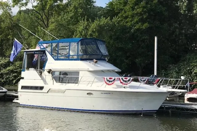The Image of 1993 Carver 370 Aft Cabin Motor Yacht docked, decorated with patriotic bunting. - 0