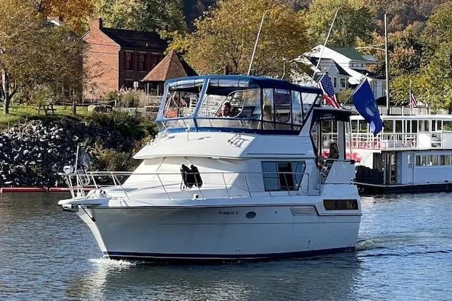 Slide: The Image of 1993 Carver 370 Aft Cabin Motor Yacht cruising on a scenic river. - 10