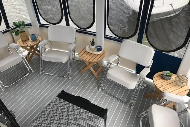 Slide: The Image of 1993 Carver 370 Aft Cabin Motor Yacht interior with white chairs and wooden tables. - 12