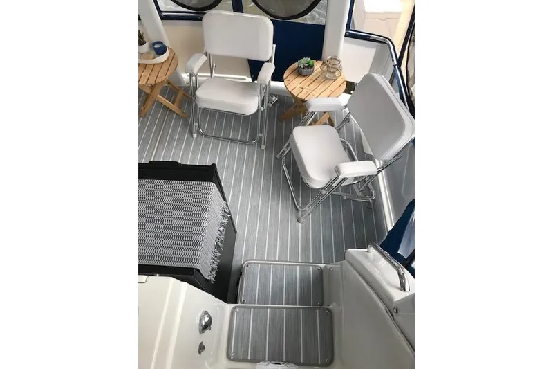 Slide: The Image of 1993 Carver 370 Aft Cabin Motor Yacht interior with chairs and table on striped flooring. - 18