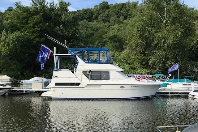 Slide: The Image of 1993 Carver 370 Aft Cabin Motor Yacht docked by lush greenery. - 3