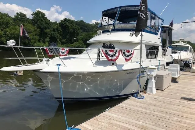 Slide: The Image of 1993 Carver 370 Aft Cabin Motor Yacht docked, decorated with festive bunting, under clear skies. - 5