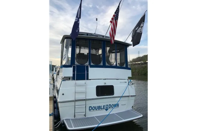 Slide: The Image of 1993 Carver 370 Aft Cabin Motor Yacht docked, displaying flags and "Double Down" name. - 6