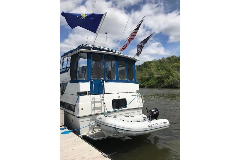Slide: The Image of 1993 Carver 370 Aft Cabin Motor Yacht docked with flags and inflatable boat. - 7