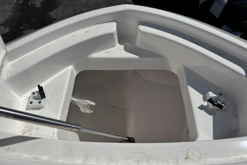 Slide: The Image of 2025 Yamaha Boats 222 FSH Sport storage compartment, open and empty, with hydraulic support. - 10