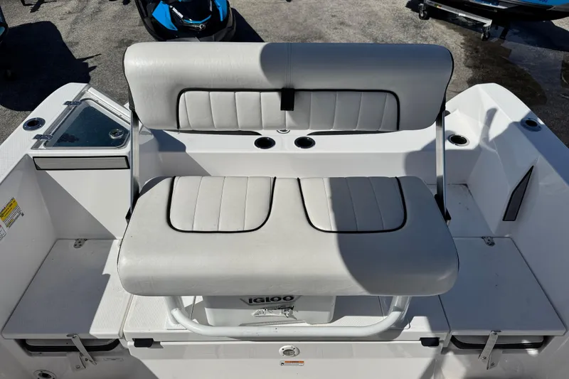 Slide: The Image of 2025 Yamaha Boats 222 FSH Sport interior seating with storage and cup holders. - 14