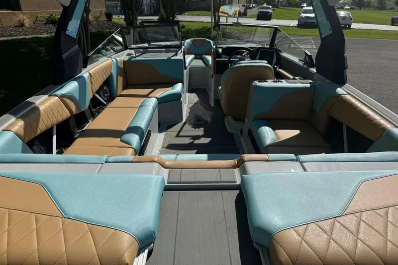 Slide: The Image of 2022 Tigé Z3 boat interior with tan and teal seating, showcasing spacious and luxurious design. - 10