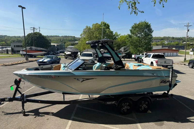 Slide: The Image of 2022 Tigé Z3 boat on trailer in parking lot, sunny day, surrounded by vehicles. - 5