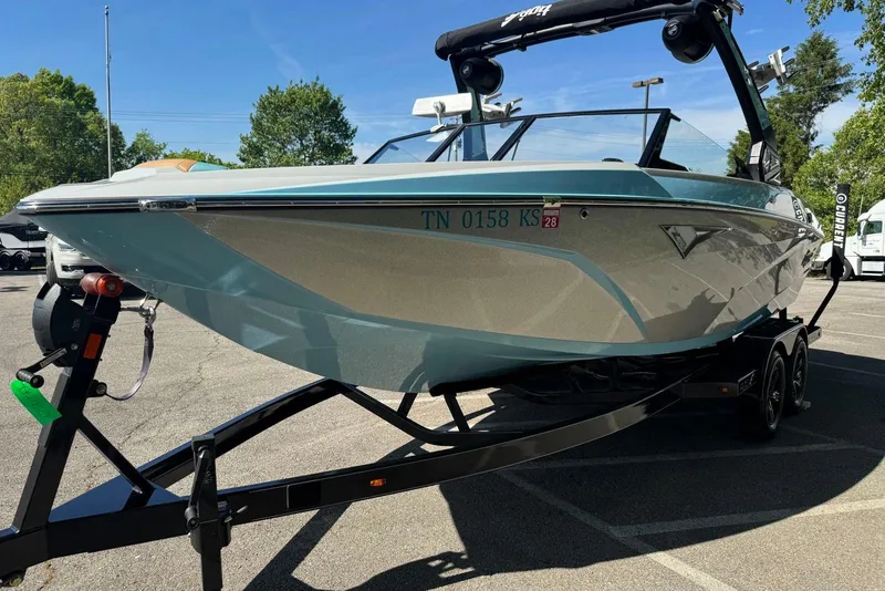 Slide: The Image of 2022 Tigé Z3 boat on trailer in parking lot, sunny day, trees in background. - 6