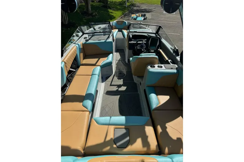 Slide: The Image of 2022 Tigé Z3 boat interior with tan and teal seating, modern dashboard, and spacious layout. - 9