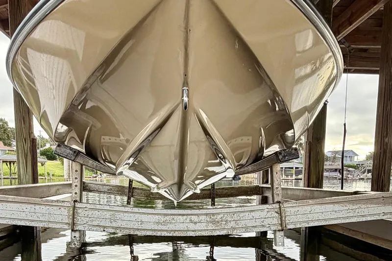 Slide: The Image of 1981 Glastron/Carlson C512 boat on lift, showcasing sleek hull design. - 5