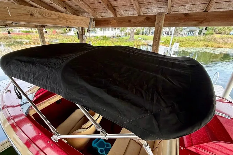 Slide: The Image of 1981 Glastron/Carlson C512 boat with black canopy under wooden dock. - 9