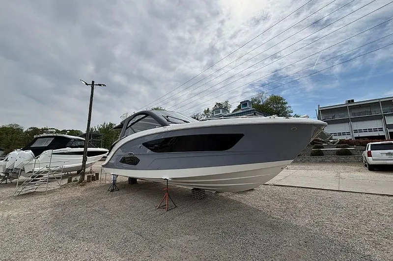 Slide: The Image of 2026 Sea Ray Sundancer 370 Outboard displayed on land under cloudy sky. - 1