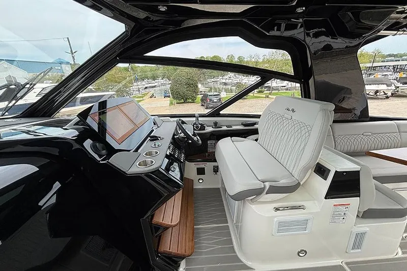 Slide: The Image of Interior of 2026 Sea Ray Sundancer 370 Outboard, featuring modern helm and seating. - 22