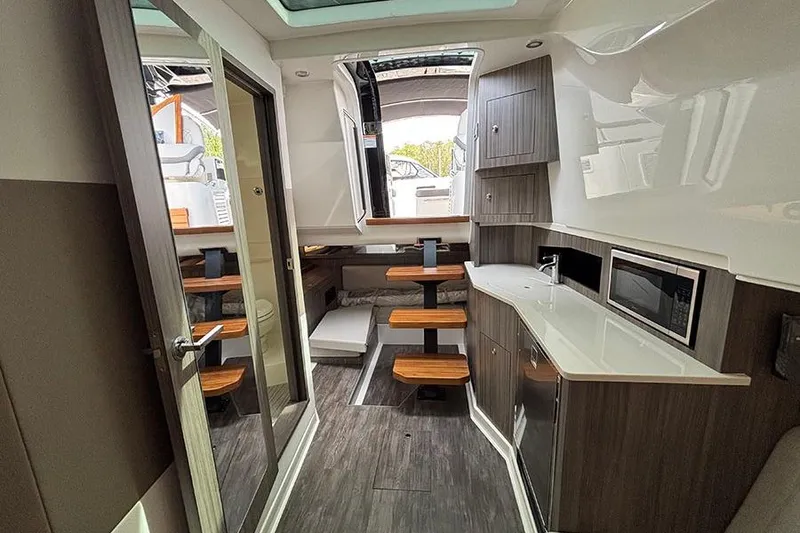 Slide: The Image of Interior of 2026 Sea Ray Sundancer 370 Outboard, featuring modern kitchen and seating area. - 31