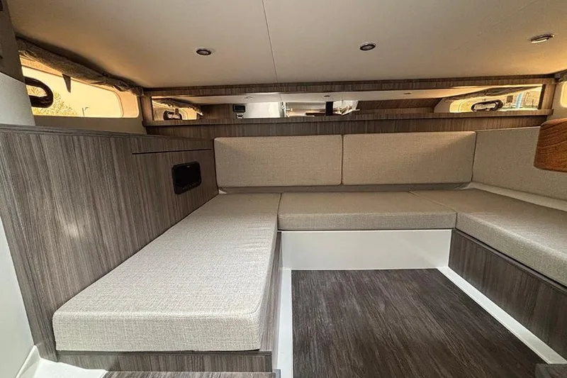 Slide: The Image of Interior of 2026 Sea Ray Sundancer 370 Outboard, featuring modern seating and wood accents. - 37