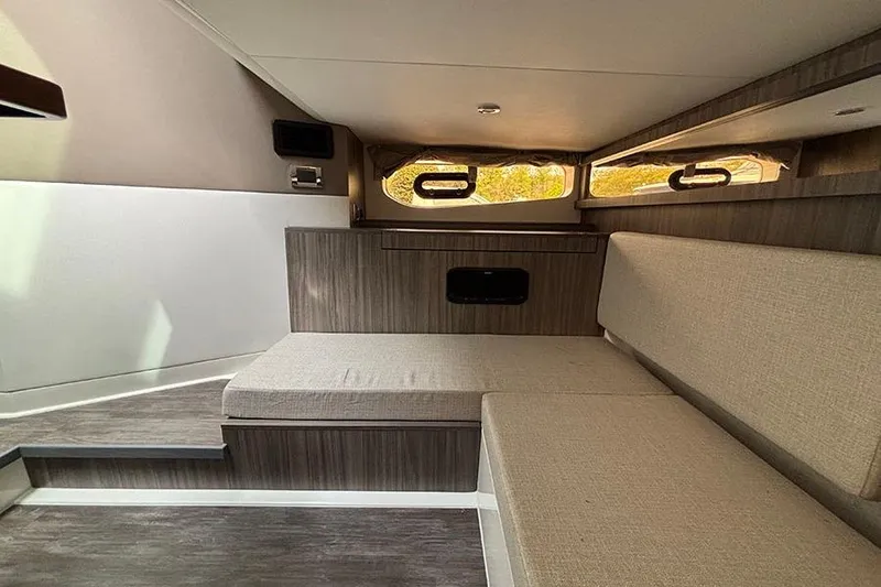 Slide: The Image of Interior cabin of 2026 Sea Ray Sundancer 370 Outboard, featuring modern seating and wood accents. - 38