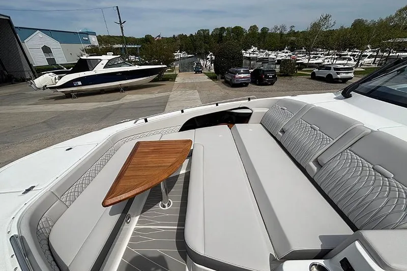 Slide: The Image of 2026 Sea Ray Sundancer 370 Outboard with elegant seating and wooden table, dockside view. - 45